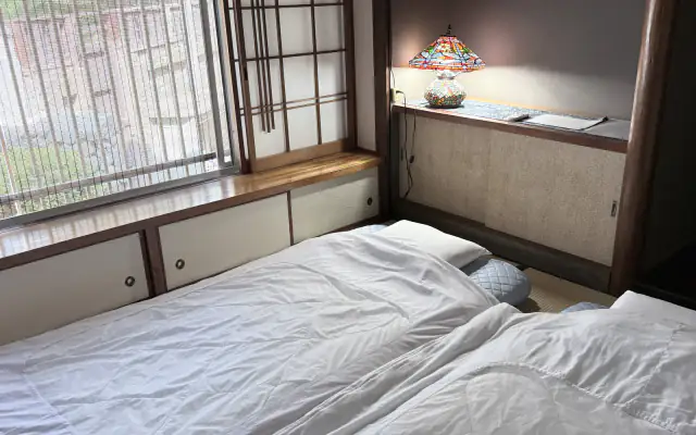 Matsu tatami room with futon, window and stained-glass lamp