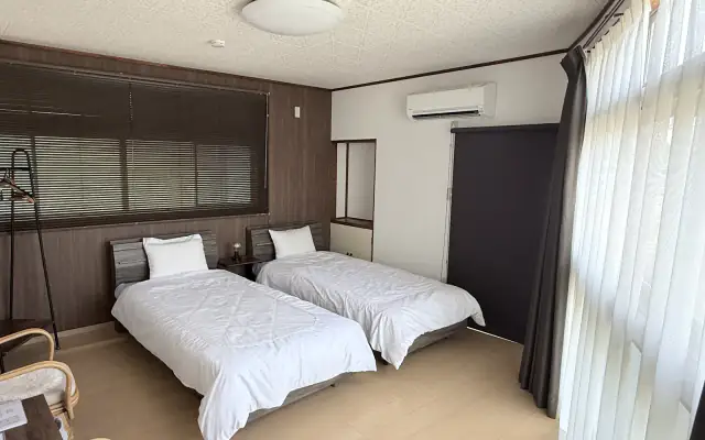 Oto room with large windows and two single beds（大きな窓とシングルベッド2台を備えた音の客室）