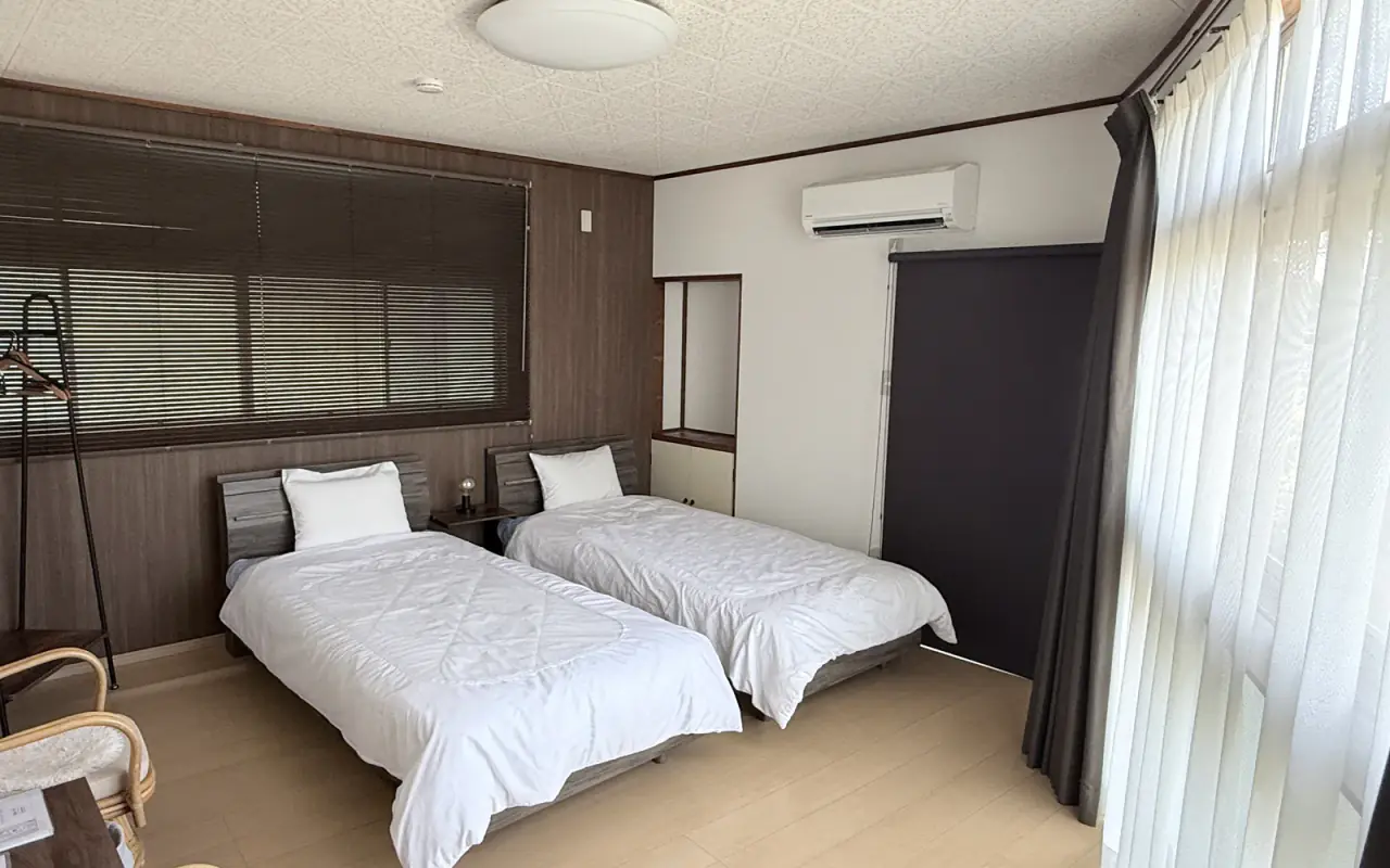 大きな窓とシングルベッド2台を備えた音の客室