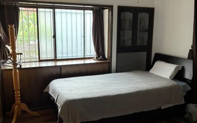 Sora room with a bed by the window（窓辺にベッドを備えた空の客室）