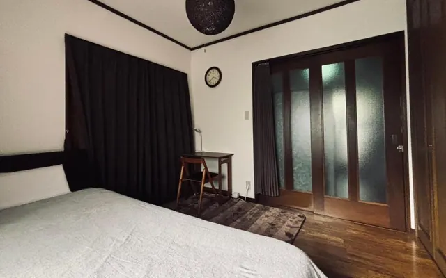 Sora room with a bed, desk and timber doors（ベッド、机、木の引き戸を備えた空の客室）