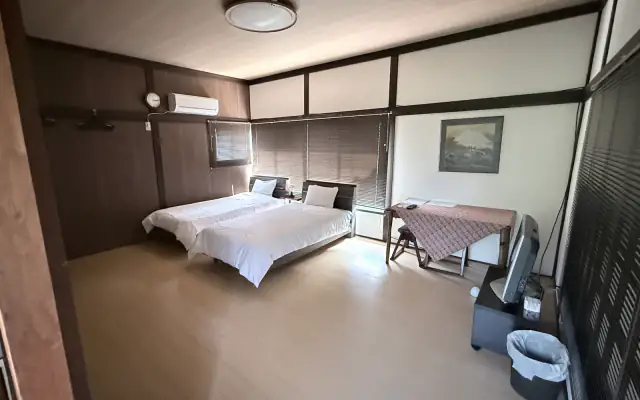 Yama room with two single beds and a wooden table