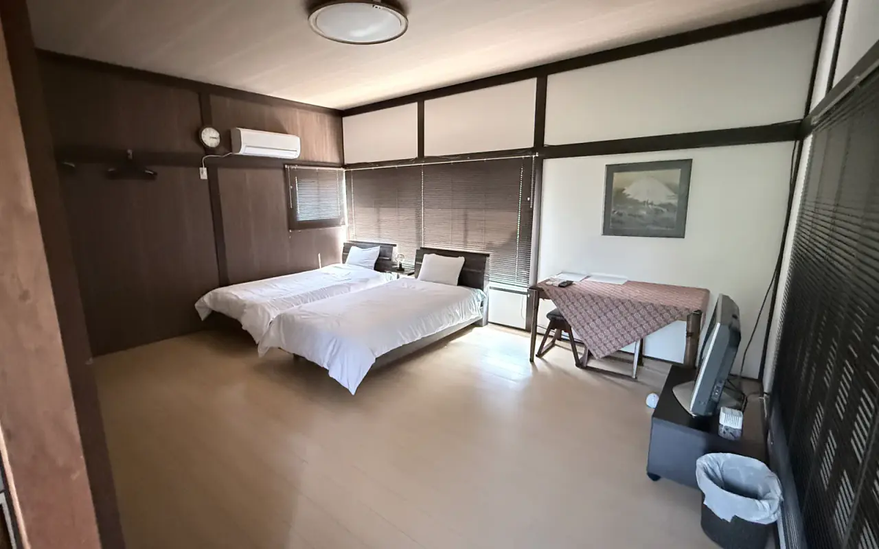 シングルベッド2台とテーブルを備えた山の客室